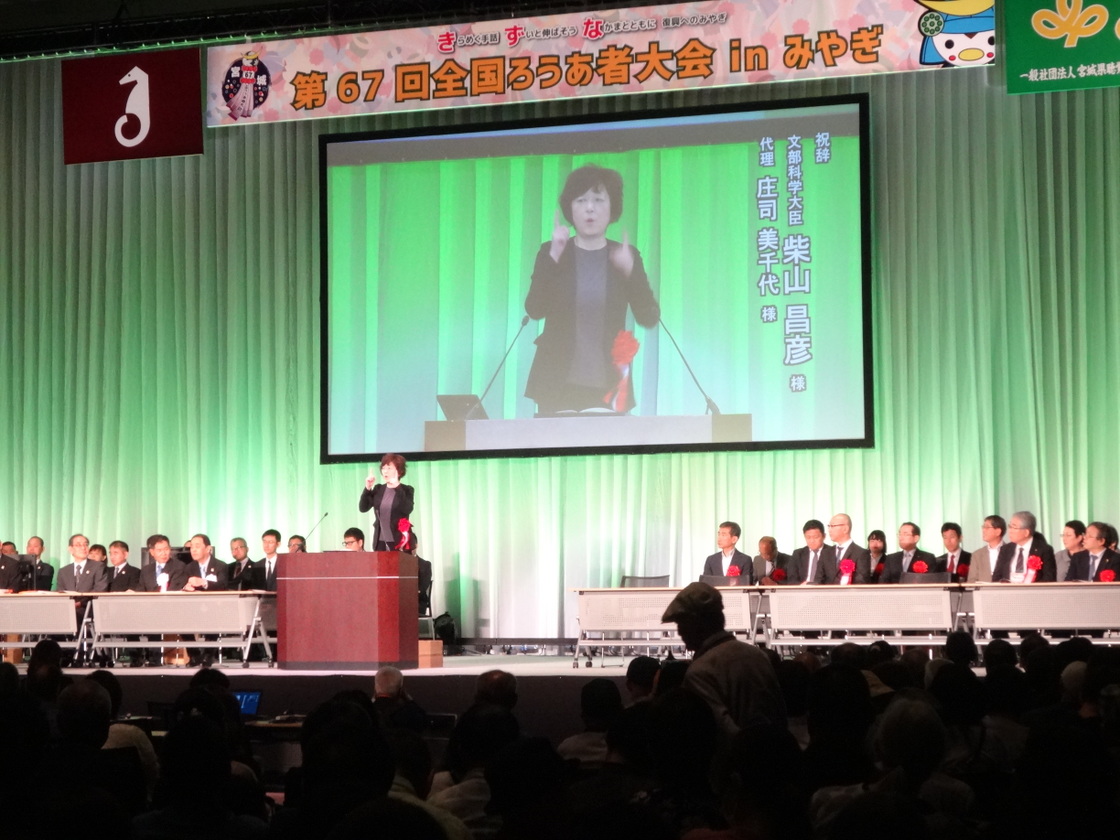 第６７回全国ろうあ者大会の様子（写真は文部科学大臣の祝辞　代理の方（女性）終始手話で申されました。）