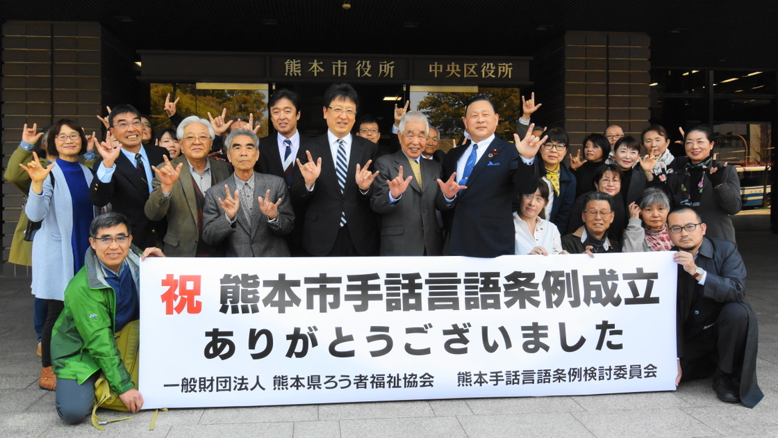 熊本市議会で採決後、大西一史熊本市長、倉重徹熊本市議会議長を囲み、熊本市役所正面玄関前で記念撮影